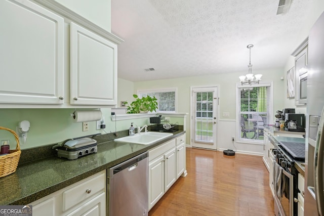 198 Lake Cv, Approach, Newnan, GA 30265 - kitchen featuring appliances with stainless steel finishes, a sink, light wood-type flooring, a chandelier, and white cabinets