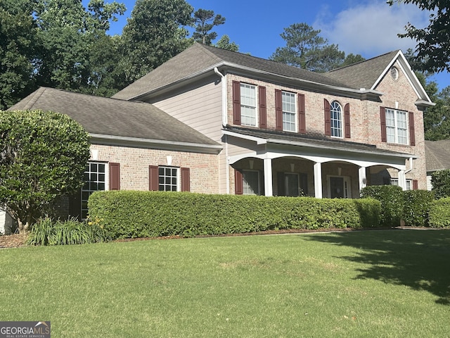 311 Arbor Point Ct SW, Lilburn, GA 30047 - view of front of property featuring brick siding, a front yard, roof with shingles, and covered porch