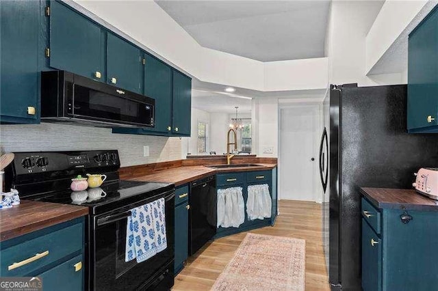 374 Dooley Rd, Dallas, GA 30132 - kitchen with black appliances, a sink, blue cabinets, and butcher block countertops