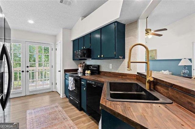 374 Dooley Rd, Dallas, GA 30132 - kitchen with black appliances, a sink, butcher block counters, a textured ceiling, and light wood-style flooring