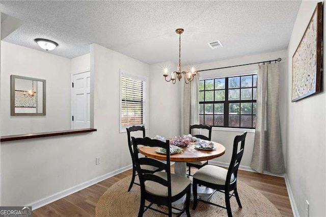 374 Dooley Rd, Dallas, GA 30132 - dining room with wood finished floors, baseboards, a chandelier, and a textured ceiling