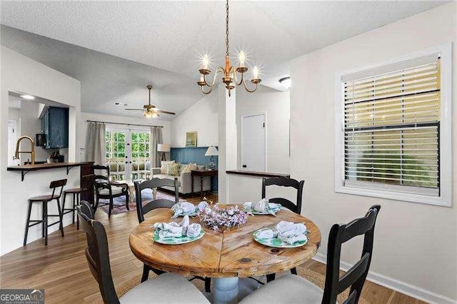 374 Dooley Rd, Dallas, GA 30132 - dining room with wood finished floors, baseboards, lofted ceiling, ceiling fan, and a chandelier