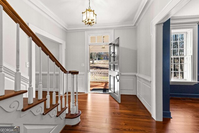 135 Mill Race Rd, Thomaston, GA 30286 - foyer entrance featuring a chandelier, dark wood-style floors, stairway, crown molding, and wainscoting
