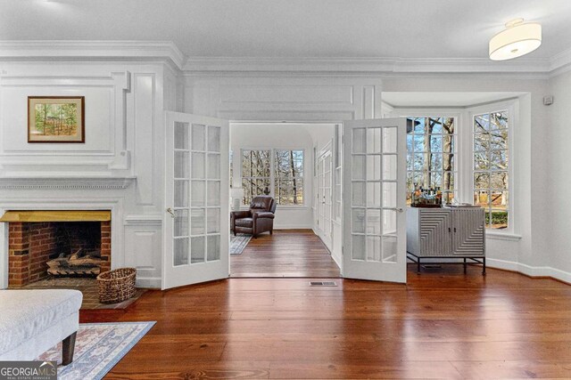 135 Mill Race Rd, Thomaston, GA 30286 - living room featuring french doors, crown molding, wood finished floors, baseboards, and a brick fireplace