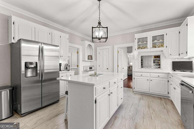 135 Mill Race Rd, Thomaston, GA 30286 - kitchen with stainless steel appliances, white cabinetry, light countertops, a chandelier, and crown molding
