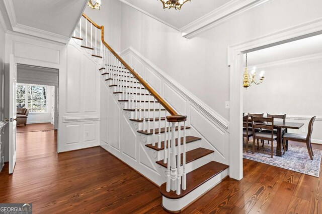 135 Mill Race Rd, Thomaston, GA 30286 - stairway with a chandelier, crown molding, wood finished floors, and a decorative wall