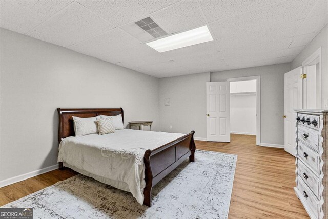 135 Mill Race Rd, Thomaston, GA 30286 - bedroom featuring a drop ceiling, light wood-type flooring, baseboards, and a spacious closet