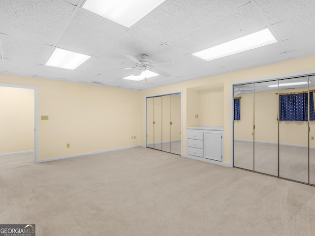 474 N Rover Rd, Williamson, GA 30292 - unfurnished bedroom with two closets, a drop ceiling, light colored carpet, baseboards, and a ceiling fan