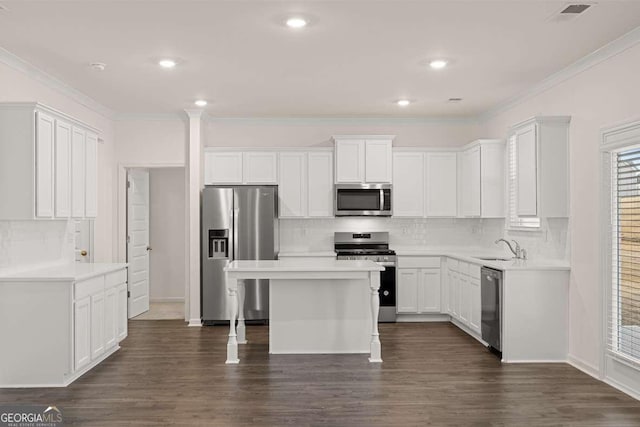1159 Blue Juniper Cir, Loganville, GA 30052 - kitchen featuring appliances with stainless steel finishes, a sink, tasteful backsplash, white cabinetry, and a breakfast bar area