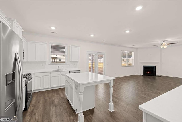 1159 Blue Juniper Cir, Loganville, GA 30052 - kitchen featuring appliances with stainless steel finishes, a sink, a kitchen breakfast bar, white cabinetry, and a ceiling fan