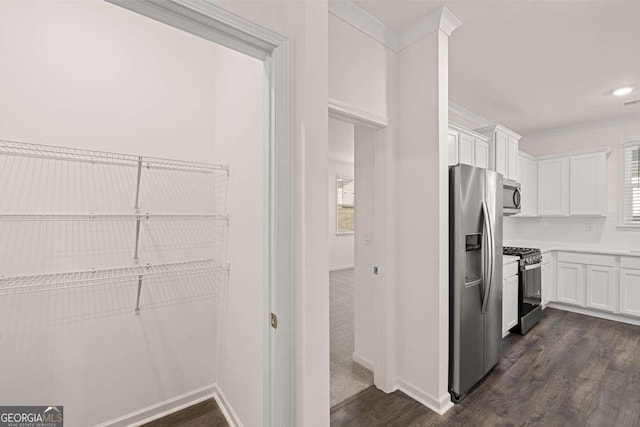 1159 Blue Juniper Cir, Loganville, GA 30052 - kitchen with stainless steel appliances, white cabinets, dark wood finished floors, light countertops, and baseboards