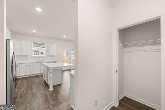 1159 Blue Juniper Cir, Loganville, GA 30052 - kitchen with white cabinets, dark wood finished floors, light countertops, stainless steel refrigerator with ice dispenser, and a center island
