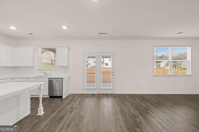1159 Blue Juniper Cir, Loganville, GA 30052 - kitchen featuring stainless steel dishwasher, crown molding, light countertops, white cabinetry, and dark wood-style floors