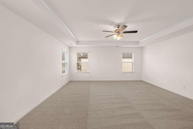 1159 Blue Juniper Cir, Loganville, GA 30052 - spare room featuring a tray ceiling, ceiling fan, baseboards, and carpet floors