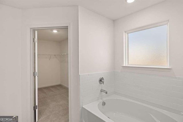 1159 Blue Juniper Cir, Loganville, GA 30052 - bathroom featuring a garden tub, a spacious closet, and recessed lighting