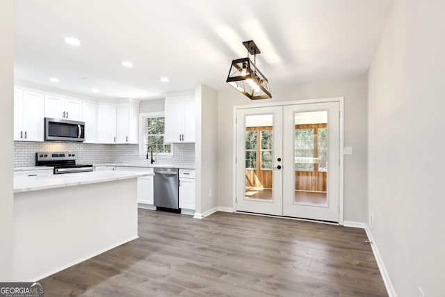 1483 Madison Rd, Monticello, GA 31064 - kitchen featuring appliances with stainless steel finishes, french doors, decorative backsplash, white cabinetry, and light countertops