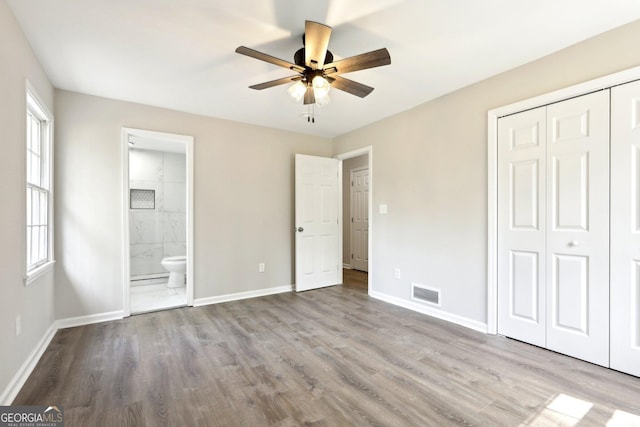 1483 Madison Rd, Monticello, GA 31064 - unfurnished bedroom with a closet, wood finished floors, baseboards, and connected bathroom