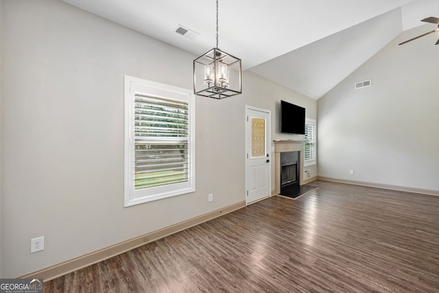1010 Holliday Pass, Griffin, GA 30223 - unfurnished living room featuring healthy amount of natural light, a chandelier, wood finished floors, a fireplace with raised hearth, and high vaulted ceiling