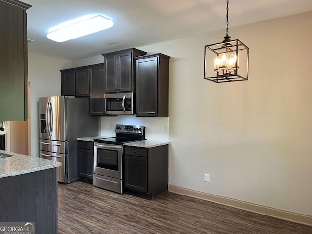1010 Holliday Pass, Griffin, GA 30223 - kitchen with stainless steel appliances, dark wood finished floors, a chandelier, decorative backsplash, and baseboards
