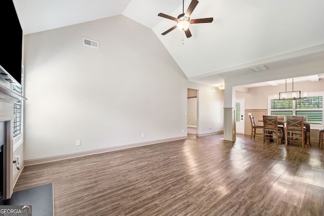 1010 Holliday Pass, Griffin, GA 30223 - living area featuring a fireplace with flush hearth, a ceiling fan, high vaulted ceiling, wood finished floors, and a chandelier