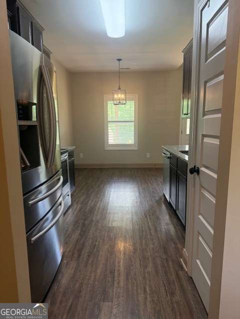 1010 Holliday Pass, Griffin, GA 30223 - kitchen featuring stainless steel appliances, baseboards, dark wood-style floors, pendant lighting, and light countertops