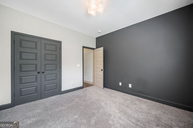 1010 Holliday Pass, Griffin, GA 30223 - unfurnished bedroom featuring carpet flooring, a chandelier, and a closet
