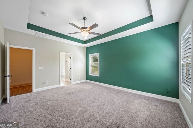 1010 Holliday Pass, Griffin, GA 30223 - unfurnished bedroom featuring a raised ceiling, carpet floors, and ceiling fan