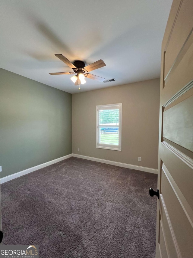 1010 Holliday Pass, Griffin, GA 30223 - spare room featuring dark colored carpet, ceiling fan, and baseboards