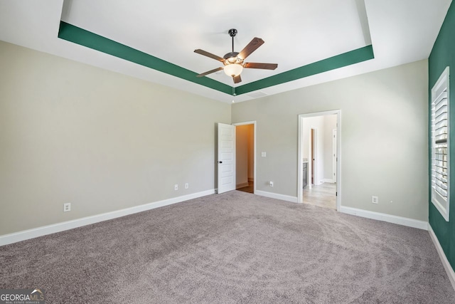 1010 Holliday Pass, Griffin, GA 30223 - unfurnished bedroom with a raised ceiling, carpet floors, and a ceiling fan