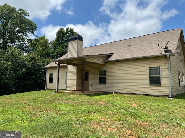 1010 Holliday Pass, Griffin, GA 30223 - rear view of house with a patio area, a chimney, a yard, and roof with shingles