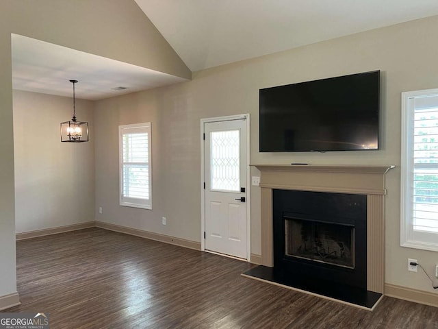 1010 Holliday Pass, Griffin, GA 30223 - unfurnished living room featuring wood finished floors, plenty of natural light, a fireplace with raised hearth, lofted ceiling, and baseboards