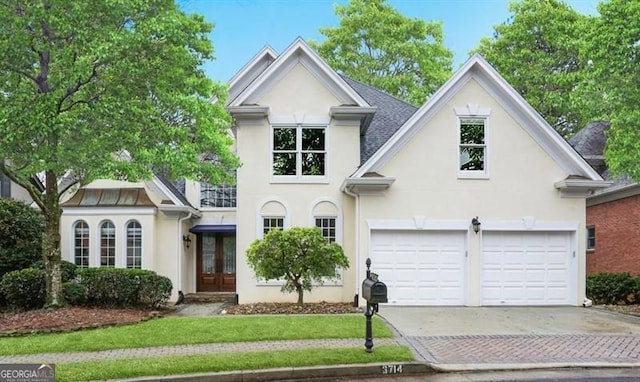 3714 Westbrooke Cir, Brookhaven, GA 30319 - view of front facade with stucco siding, driveway, french doors, a garage, and a balcony