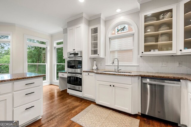 3714 Westbrooke Cir, Brookhaven, GA 30319 - kitchen featuring appliances with stainless steel finishes, a sink, crown molding, stone countertops, and backsplash