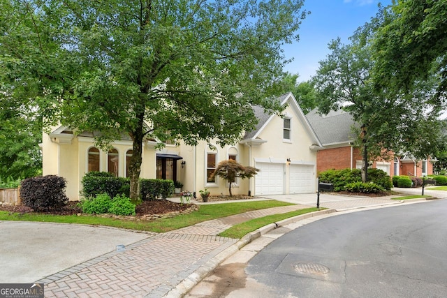 3714 Westbrooke Cir, Brookhaven, GA 30319 - obstructed view of property featuring driveway, a garage, and stucco siding