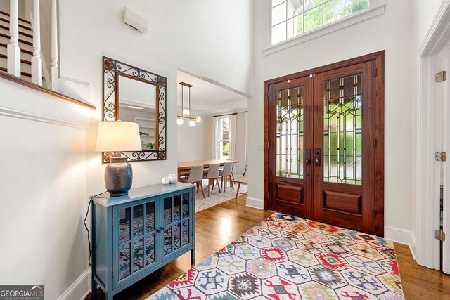 3714 Westbrooke Cir, Brookhaven, GA 30319 - foyer with plenty of natural light, french doors, wood finished floors, a towering ceiling, and a chandelier