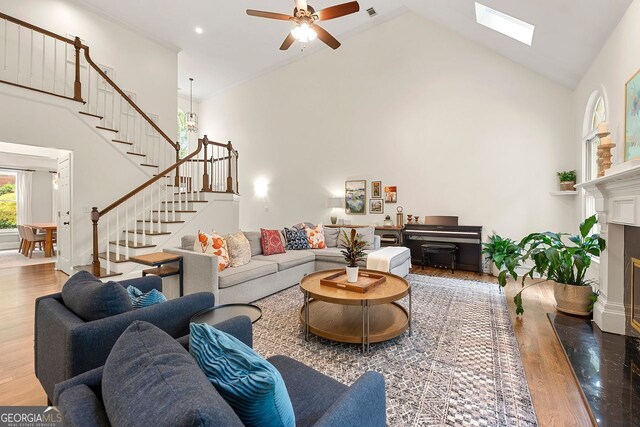 3714 Westbrooke Cir, Brookhaven, GA 30319 - living room with high vaulted ceiling, stairs, wood finished floors, ceiling fan, and a premium fireplace
