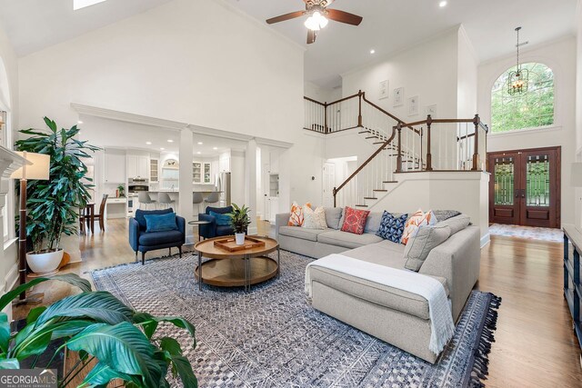 3714 Westbrooke Cir, Brookhaven, GA 30319 - living room with a high ceiling, wood finished floors, stairway, a ceiling fan, and ornamental molding