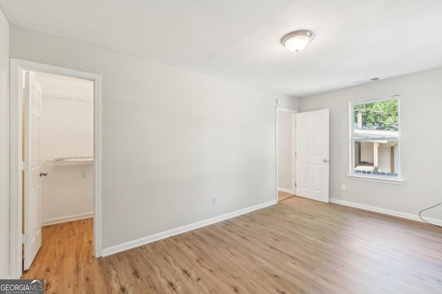 1177 Arlington Ave SW, Atlanta, GA 30310 - unfurnished bedroom with light wood-style floors, a spacious closet, baseboards, and a closet