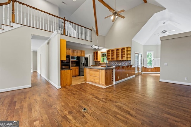 1451 Tappan Spur Dr, Watkinsville, GA 30677 - kitchen featuring a ceiling fan, open floor plan, appliances with stainless steel finishes, high vaulted ceiling, and glass insert cabinets