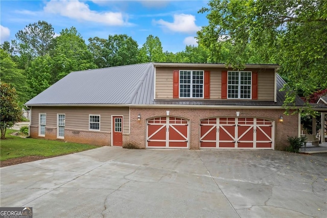 1451 Tappan Spur Dr, Watkinsville, GA 30677 - view of front of house with brick siding, driveway, metal roof, and a front yard