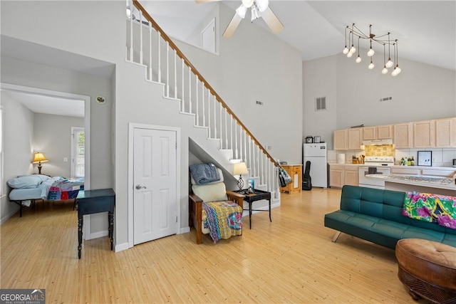 1451 Tappan Spur Dr, Watkinsville, GA 30677 - living area featuring high vaulted ceiling, light wood-type flooring, stairway, a ceiling fan, and baseboards