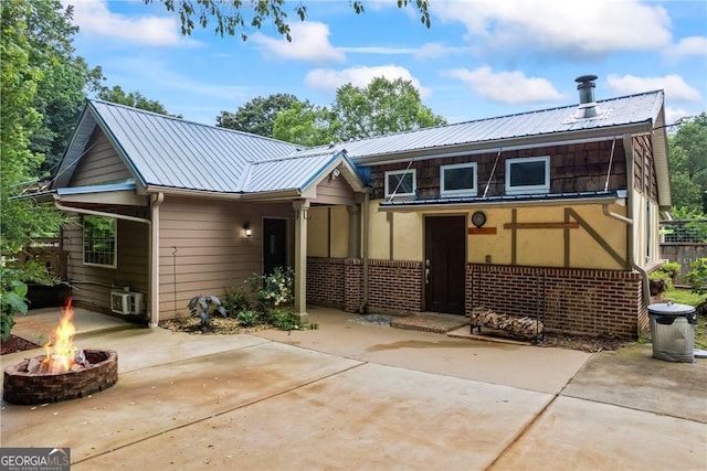 1451 Tappan Spur Dr, Watkinsville, GA 30677 - back of house featuring an outdoor fire pit, a patio, brick siding, and metal roof