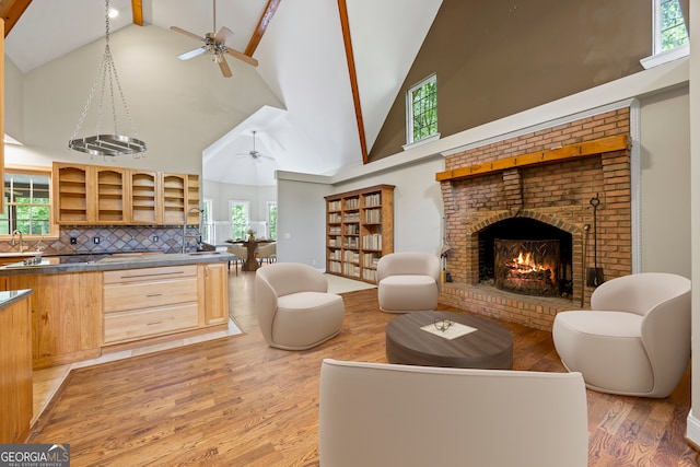 1451 Tappan Spur Dr, Watkinsville, GA 30677 - living area with high vaulted ceiling, ceiling fan, light wood-style floors, a brick fireplace, and beamed ceiling