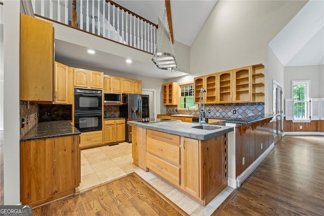 1451 Tappan Spur Dr, Watkinsville, GA 30677 - kitchen with black appliances, glass insert cabinets, decorative backsplash, a sink, and healthy amount of natural light