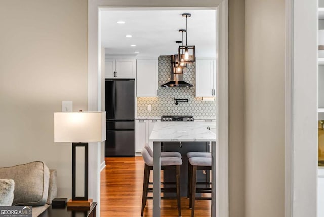 2356 Defoors Ferry Rd NW, Atlanta, GA 30318 - kitchen with freestanding refrigerator, backsplash, white cabinetry, a breakfast bar, and wood finished floors