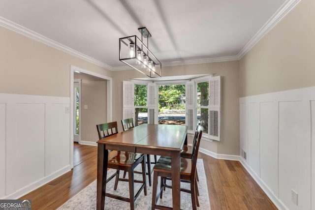 2356 Defoors Ferry Rd NW, Atlanta, GA 30318 - dining room featuring ornamental molding, wood finished floors, a decorative wall, and wainscoting