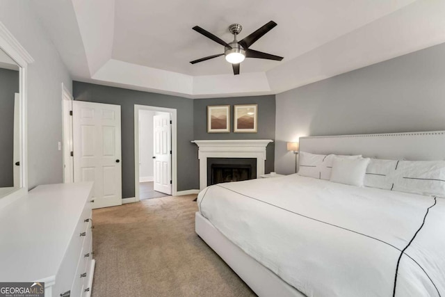 2356 Defoors Ferry Rd NW, Atlanta, GA 30318 - bedroom featuring a tray ceiling, light colored carpet, baseboards, a ceiling fan, and a fireplace
