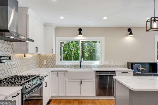 2356 Defoors Ferry Rd NW, Atlanta, GA 30318 - kitchen with stainless steel dishwasher, wall chimney exhaust hood, black range with gas cooktop, a sink, and white cabinets