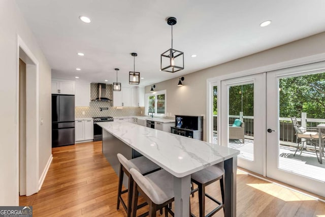2356 Defoors Ferry Rd NW, Atlanta, GA 30318 - kitchen featuring freestanding refrigerator, wall chimney exhaust hood, gas stove, healthy amount of natural light, and recessed lighting