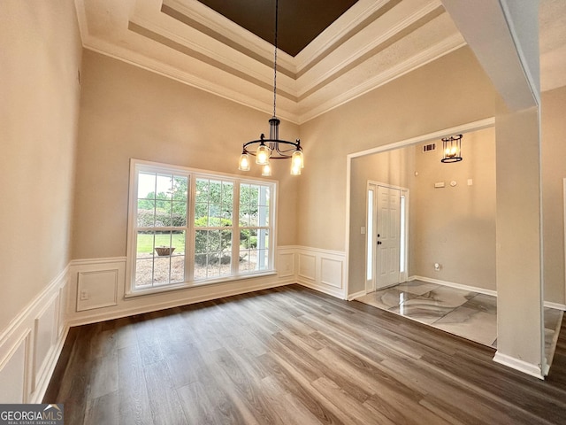 2999 Plantation Run Ct, Loganville, GA 30052 - entryway with a chandelier, crown molding, a wainscoted wall, a raised ceiling, and a decorative wall